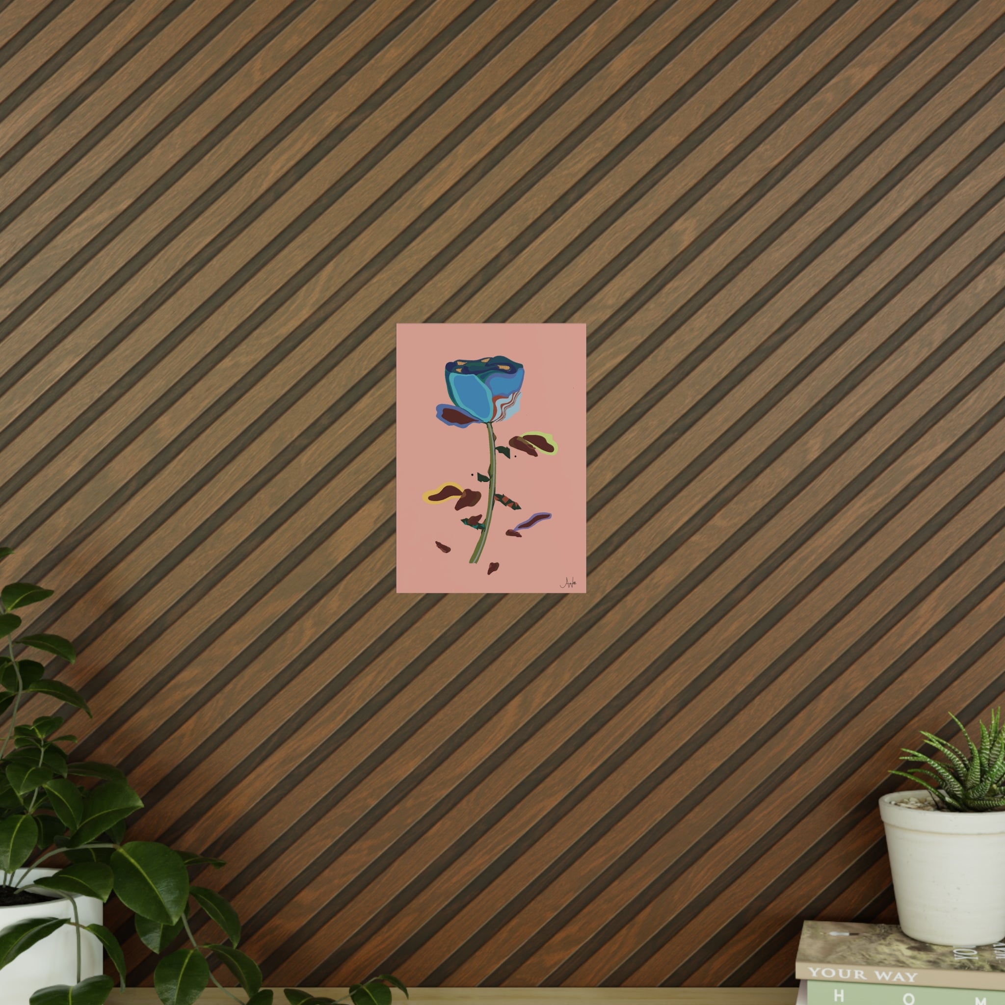 Art print of a blue rose on a pink background against a striped wall.