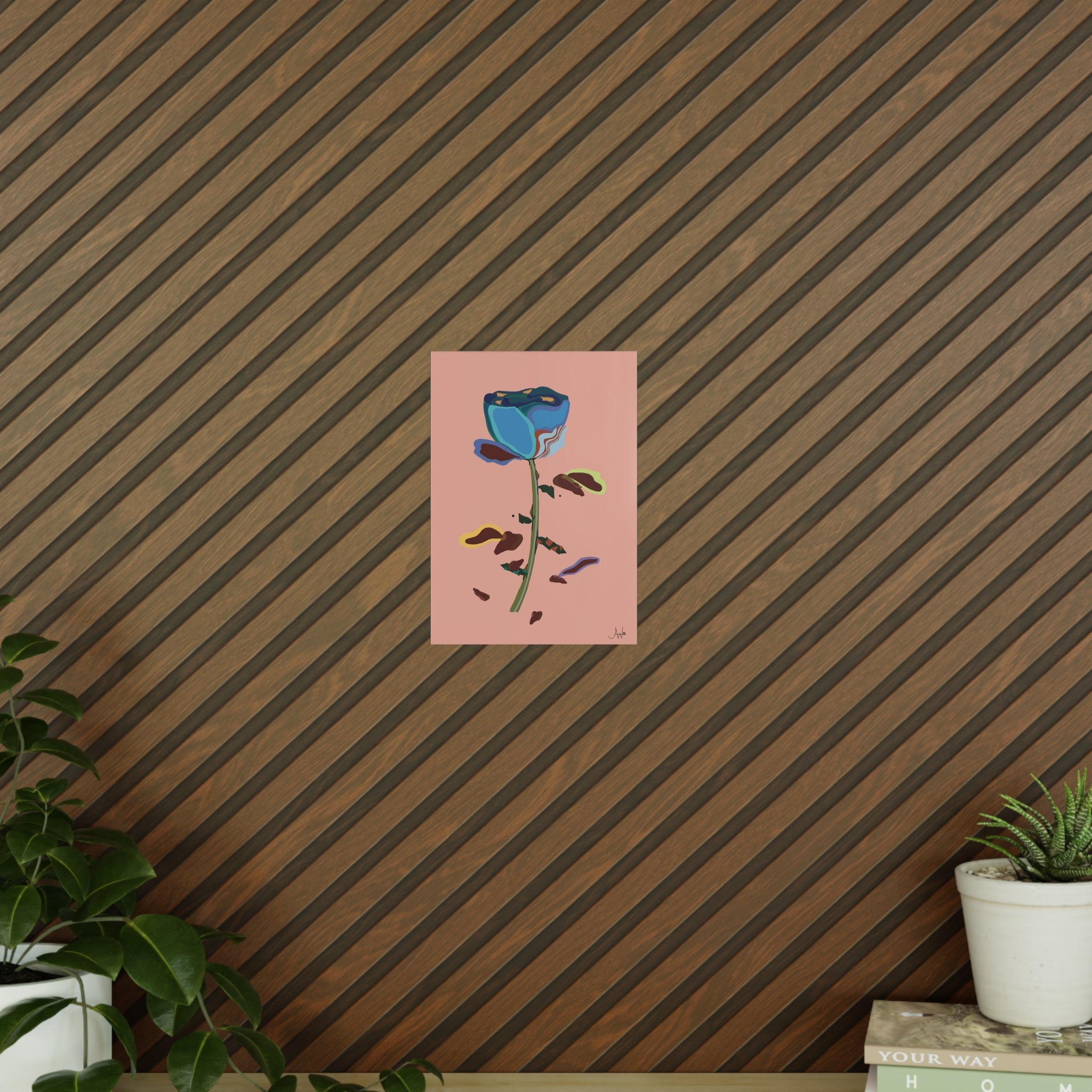 Art print of a blue rose on a pink background against a striped wall.