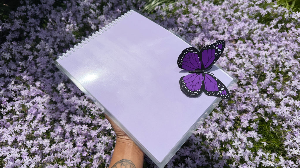 The back of a purple coloring book with a purple and black butterfly placed in the right bottom corner. 