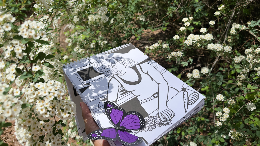 Notebook with a butterfly illustration held in front of white flowers